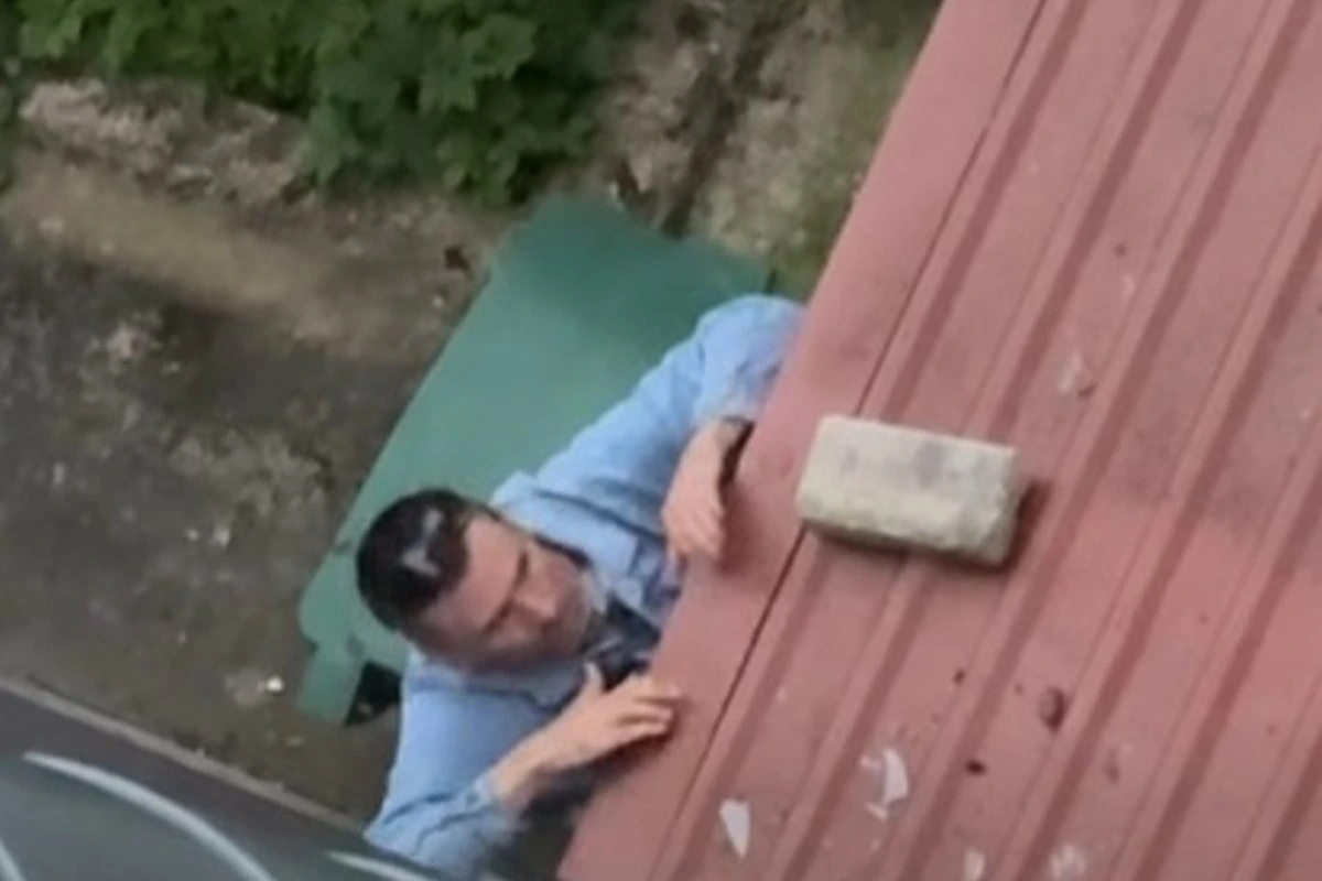 В Нарве мужчина залез на стену и кирпичом разбил окно салона красоты. Это сняли на видео